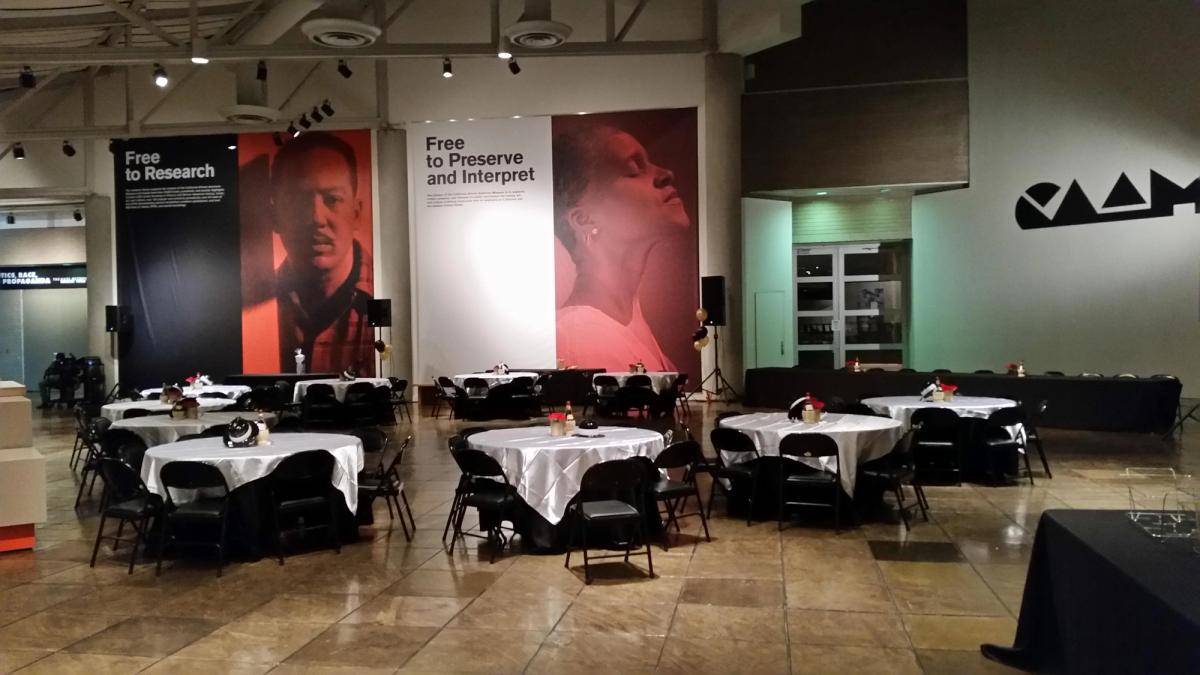 View of atrium set up with tables with tablecloths and a PA system