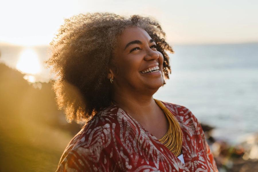 Woman near near the ocean, thinking about how to apply for Social Security while looking forward to retirement