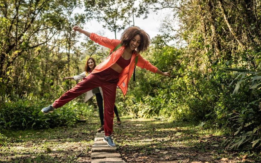 Young women walking on stones during hiking in the forest