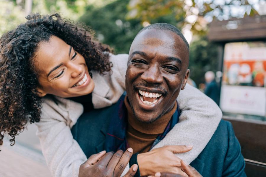A happy couple laughs while embracing outdoors, illustrating the financial security and confidence that comes with well-planned retirement income strategies.