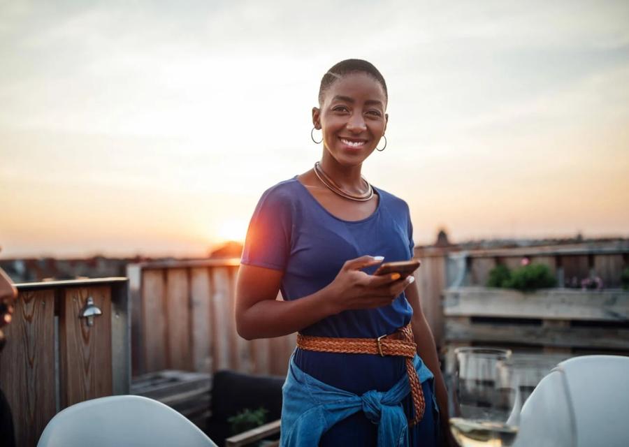 Boldin member on a rooftop at sunset holding a phone