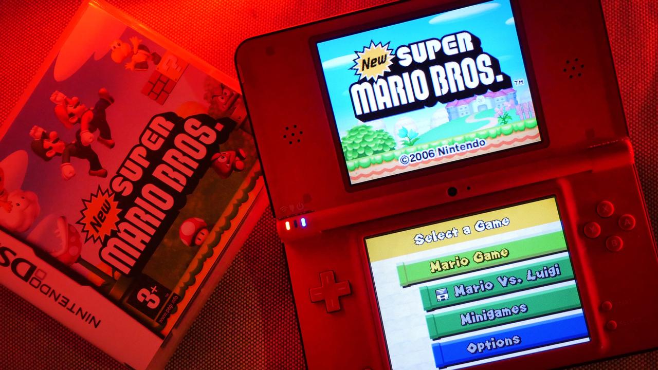New Super Mario Bros., proj. Shigeyuki Asuke; po prawej: konsola Nintendo DSi XL z włączoną grą.