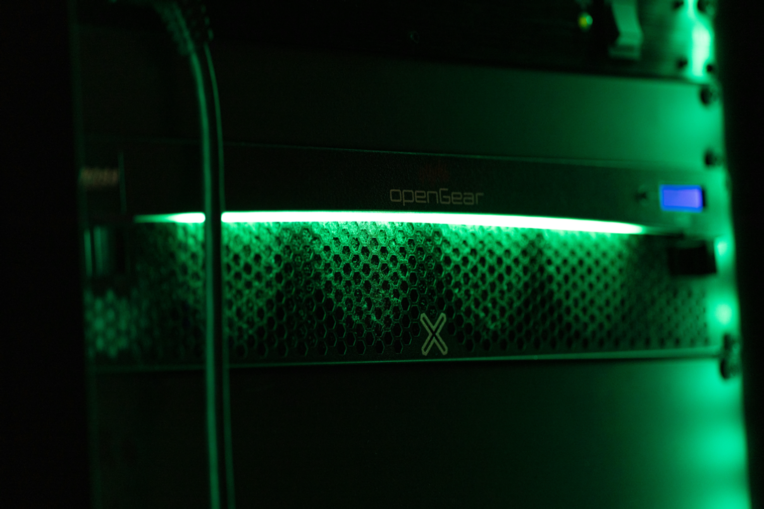 Green status light on a server: Close-up of a green status light on a server rack in a dark room