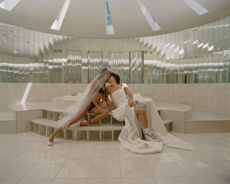 two people in a mirrored room kissing