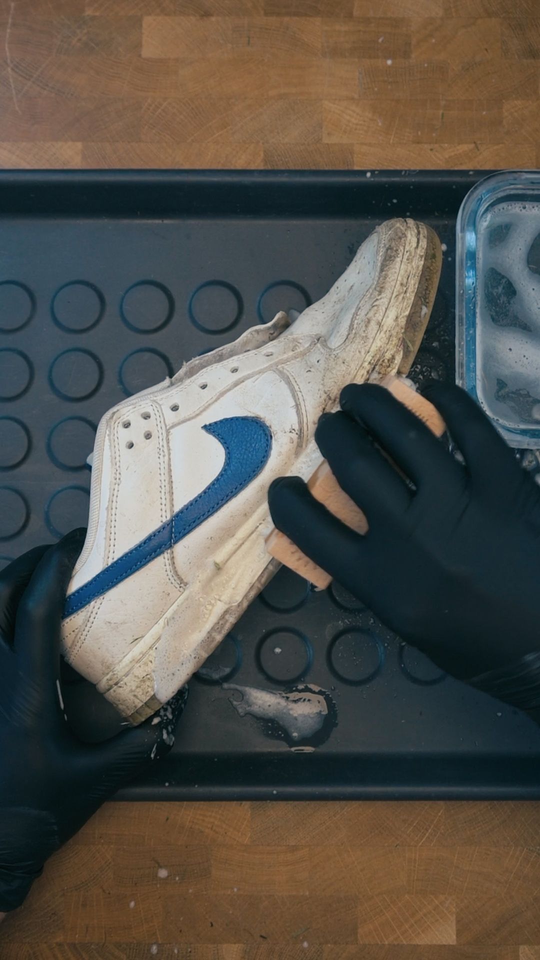 Tvätta sulan på sneakers med hård borste och rengöringsmedel för att få bort smuts och scuff marks