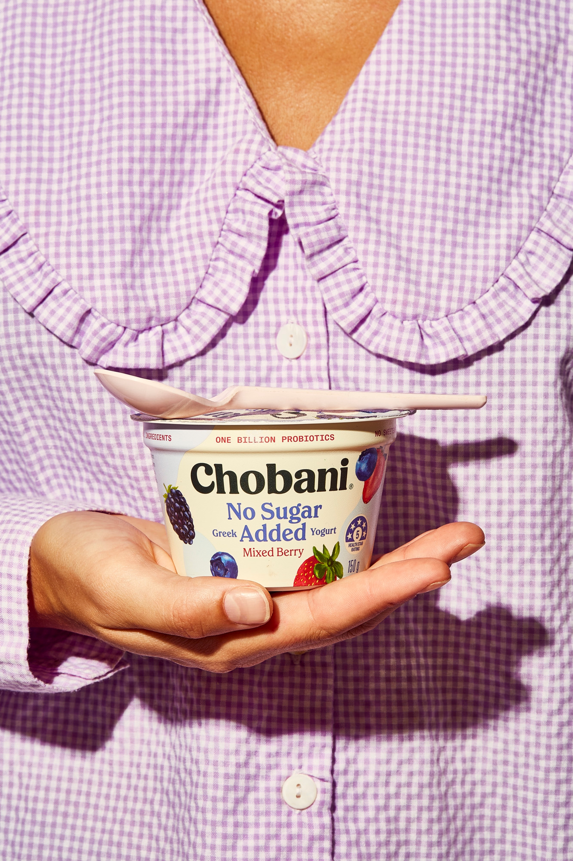 Woman wearing gingham top holding packaging designed by Our Revolution for Chobani No Sugar Added Yogurt Jen Doran