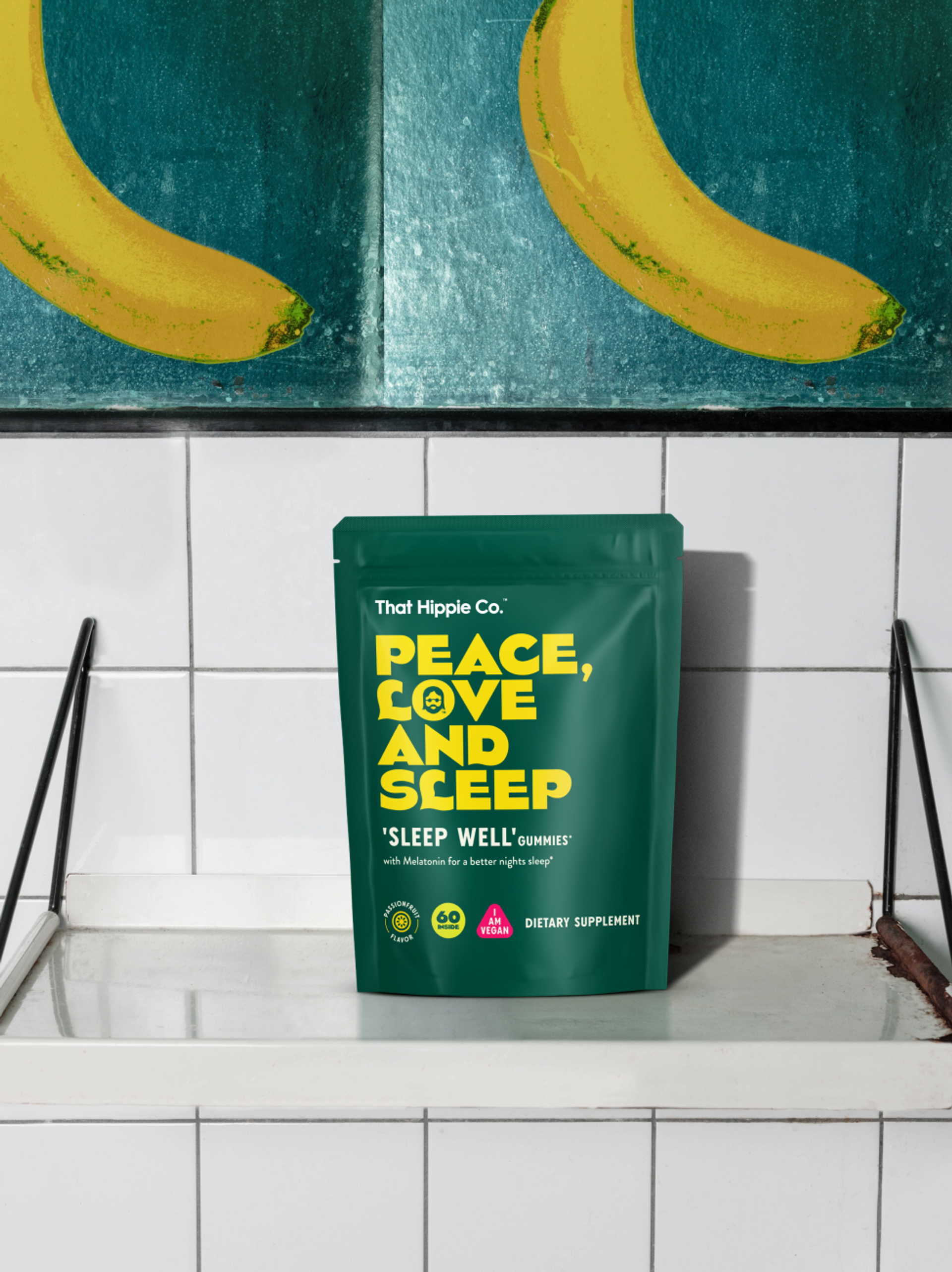 Gummies packaging design for That Hippie Co. “Sleep Well” gummies by London brand agency Our Revolution in a tiled kitchen, under a painted cupboard depicting two bananas