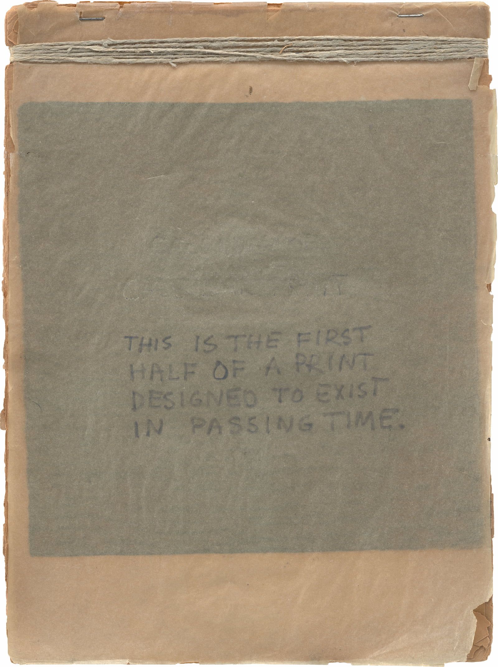 A worn, brown paper booklet with a translucent cover page featuring handwritten text that reads, "THIS IS THE FIRST HALF OF A PRINT DESIGNED TO EXIST IN PASSING TIME.