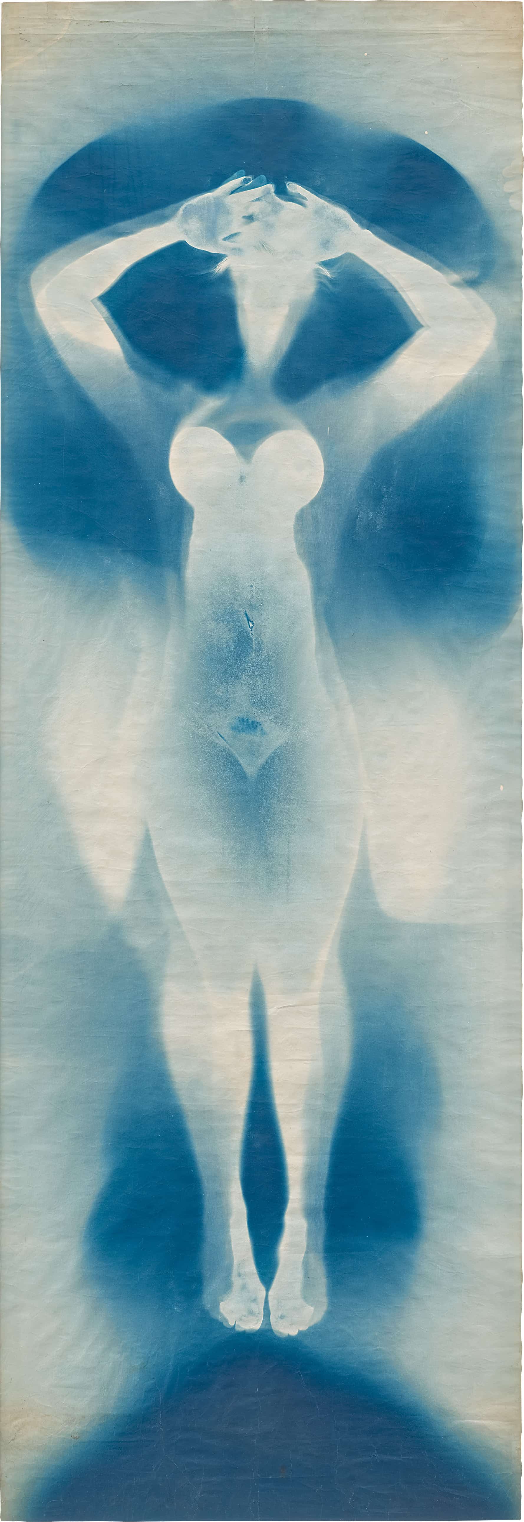 A vertical cyanotype artwork depicting a ghostly silhouette of a standing figure with arms raised, set against a lighter background.