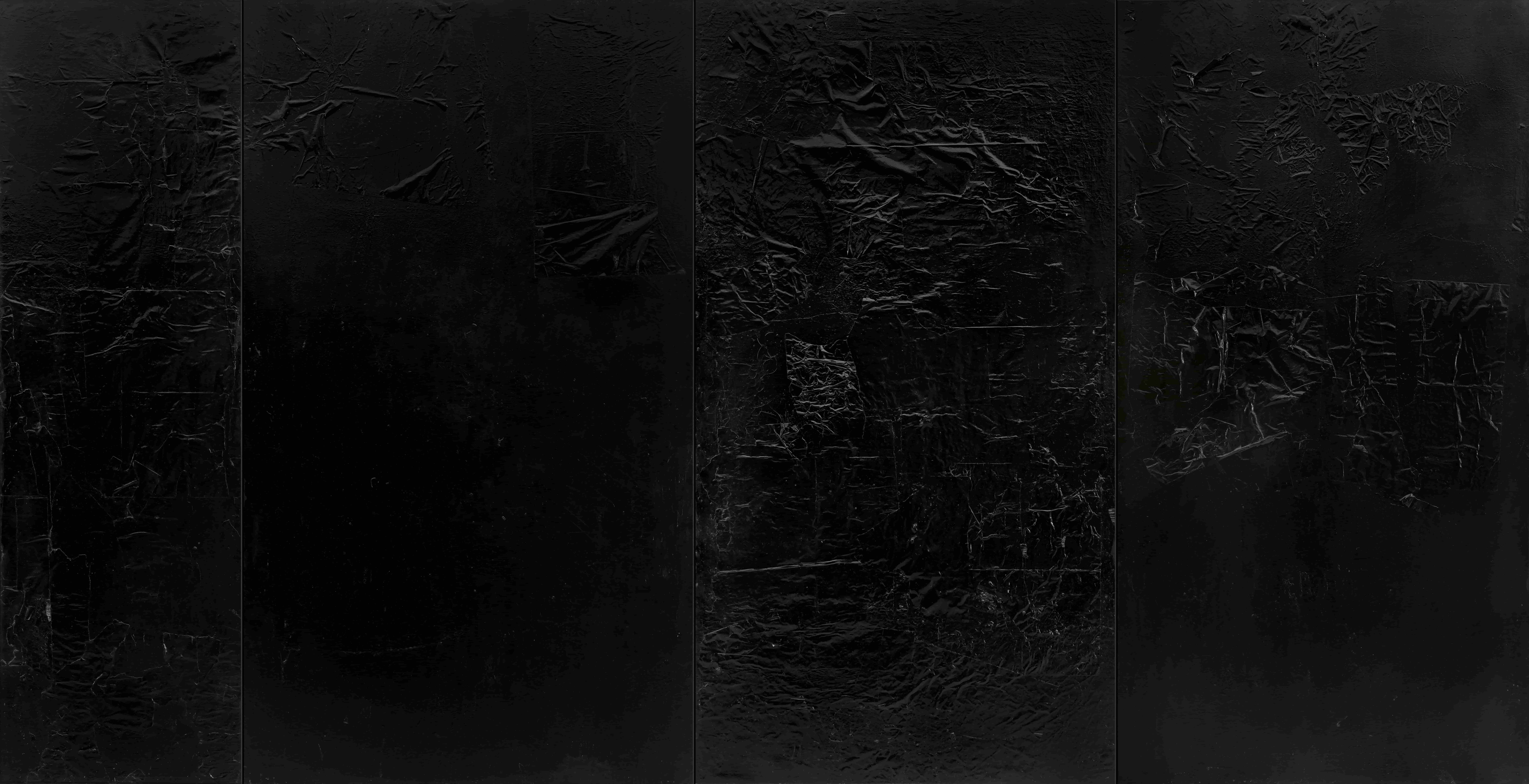 A textured black surface with varying patterns and finishes, creating a visually rich and abstract appearance.
