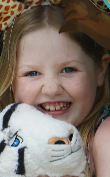 Alyna holding a stuffed tiger smiling