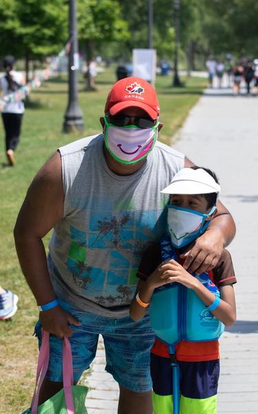 Man and his child wearing happy masks