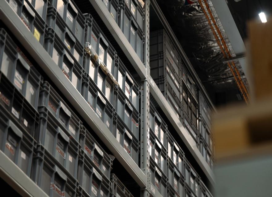 Industrial shelves holding organized plastic boxes.
