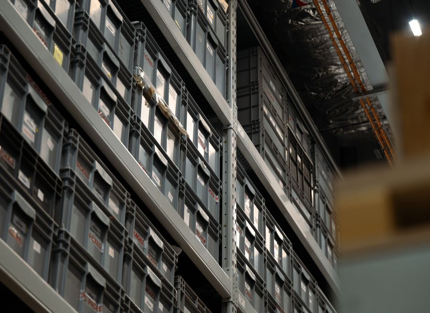 Industrial shelves holding organized plastic boxes.