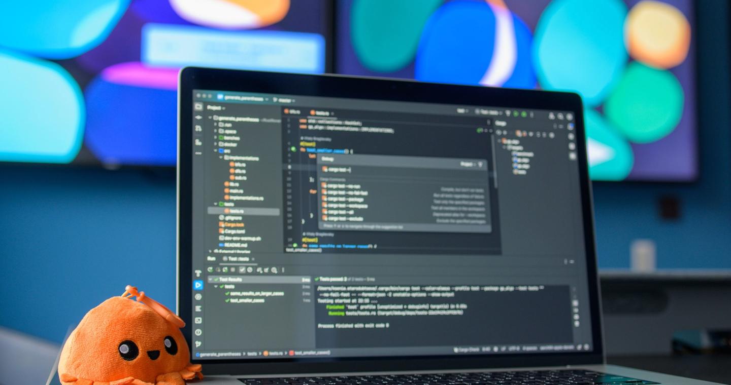 A laptop and external screens on a developer's desk.