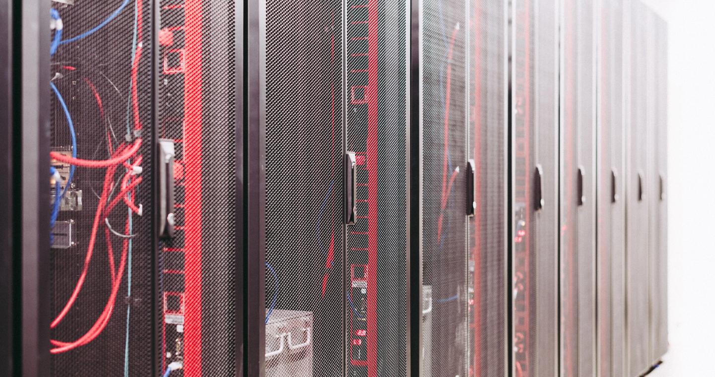 Rows of server racks with cables in a data center.