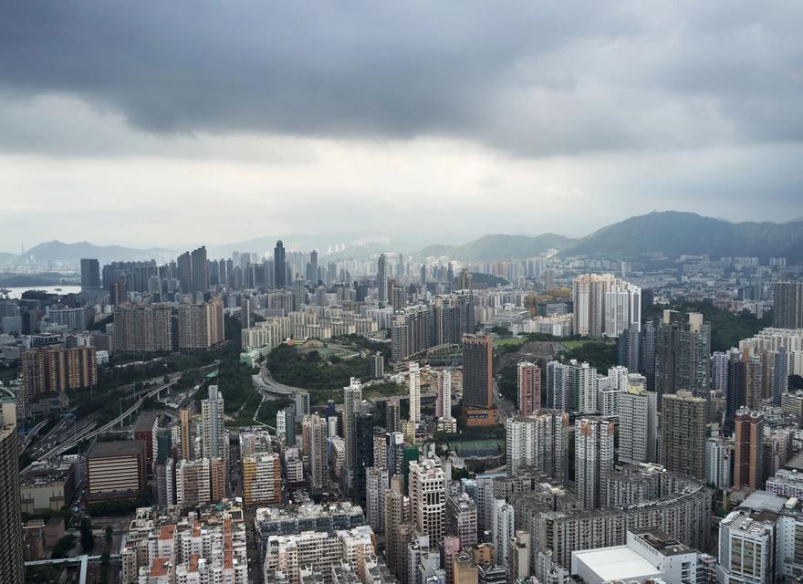 Dense buildings in Kowloon beneath a cloudy sky.
