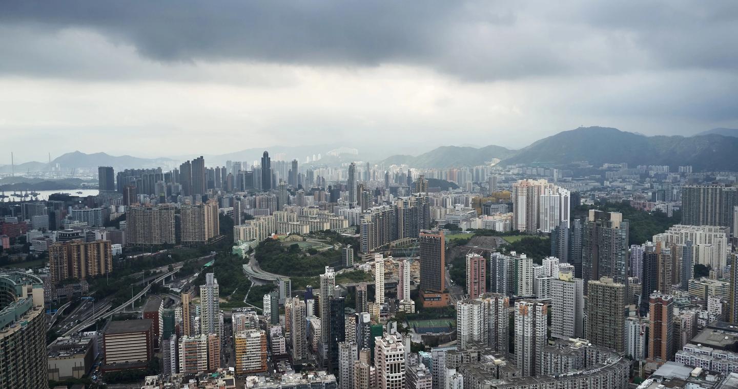 Dense buildings in Kowloon beneath a cloudy sky.