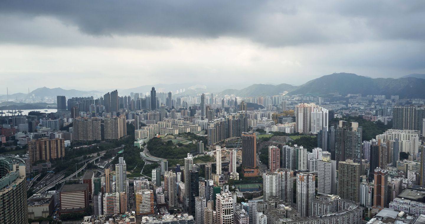 Dense buildings in Kowloon beneath a cloudy sky.