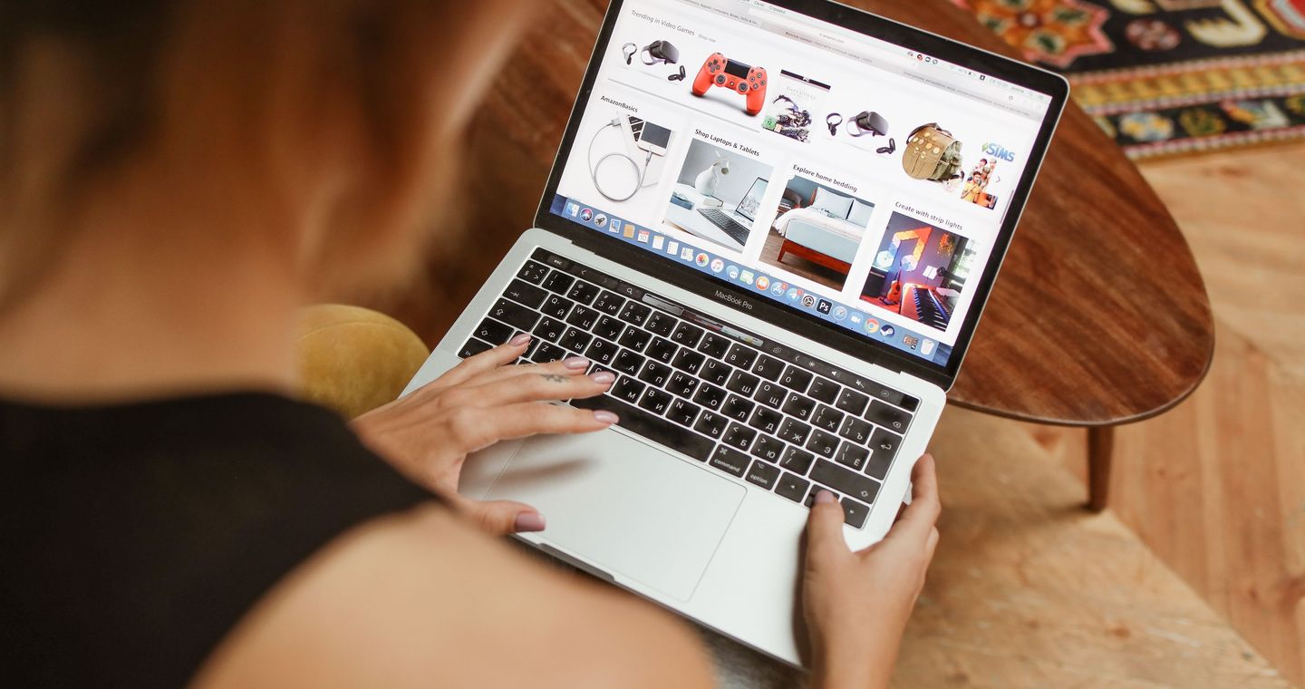 A woman browsing products on a laptop at home.