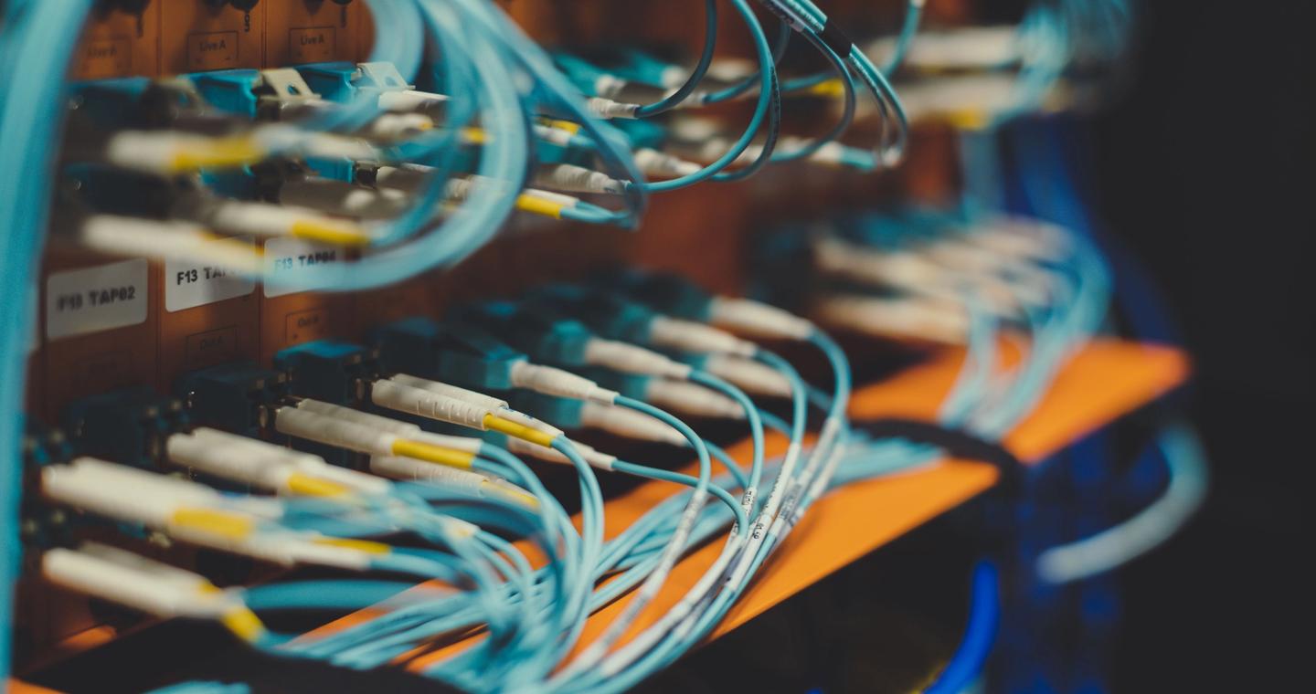 Blue network cables plugged into a server rack.