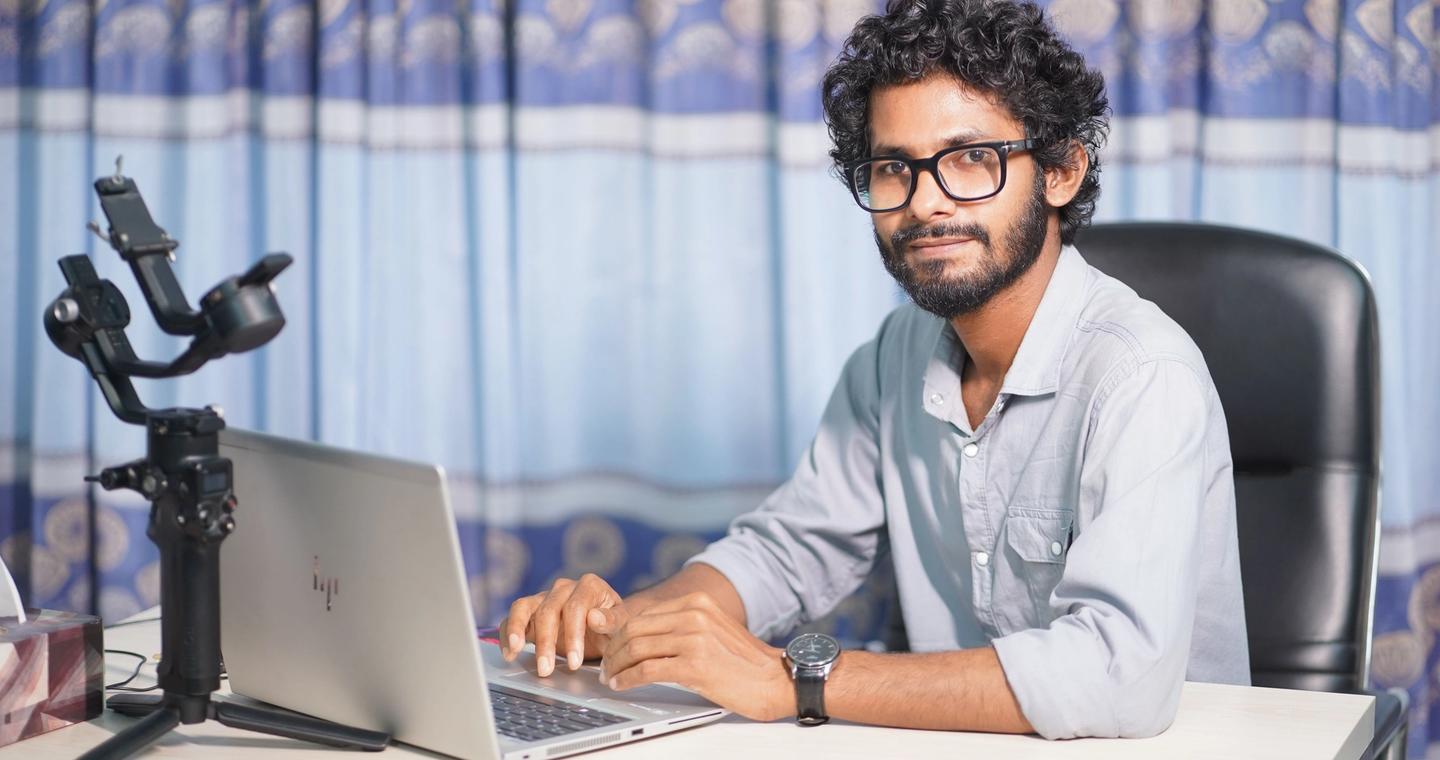 A developer works at a desk with a laptop and camera.