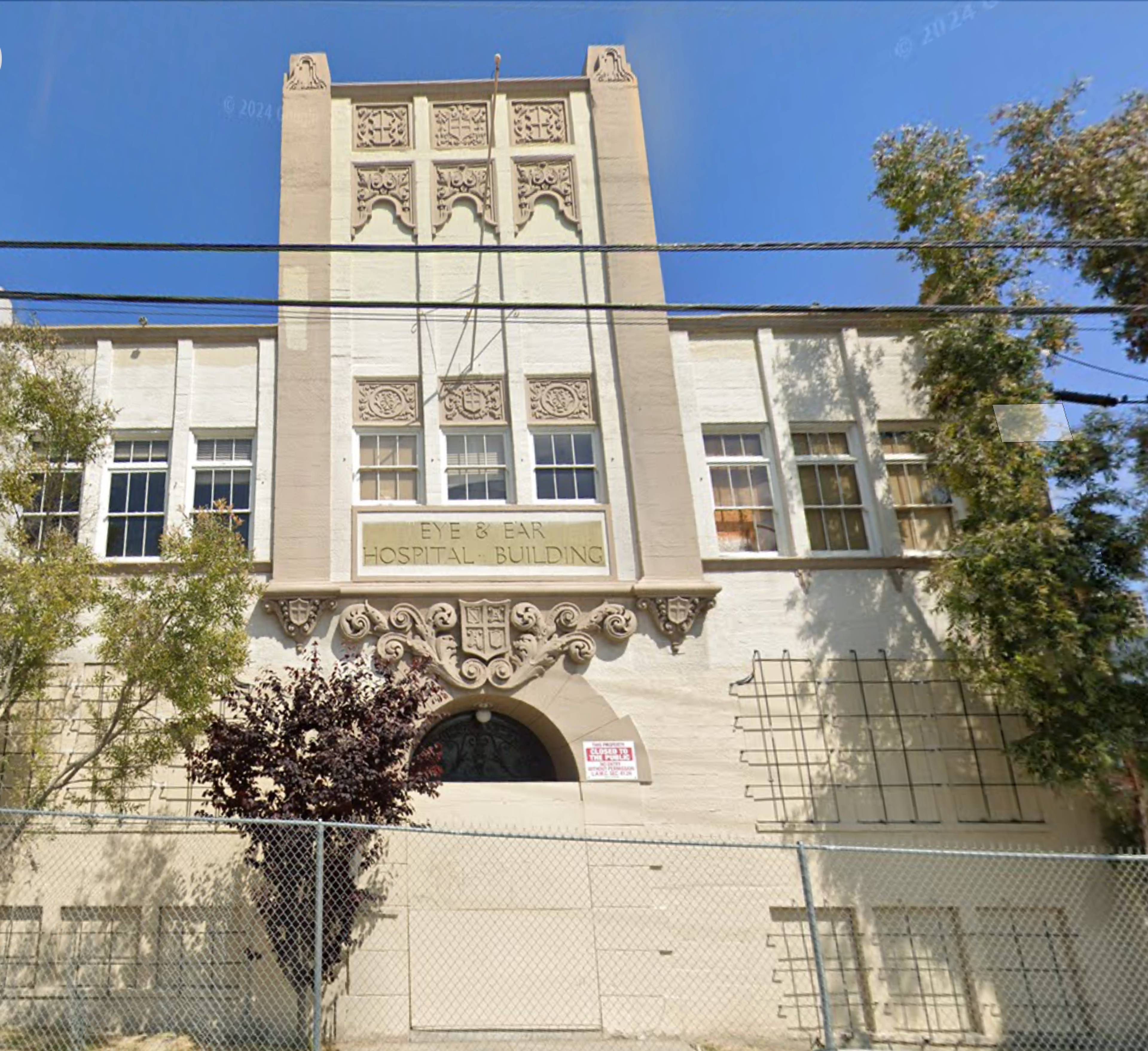 Screenshot of 500 Lucas Avenue, a beige and cream Gothic medical building. Signage above the doors reads "Eye & Ear Hospital Building".