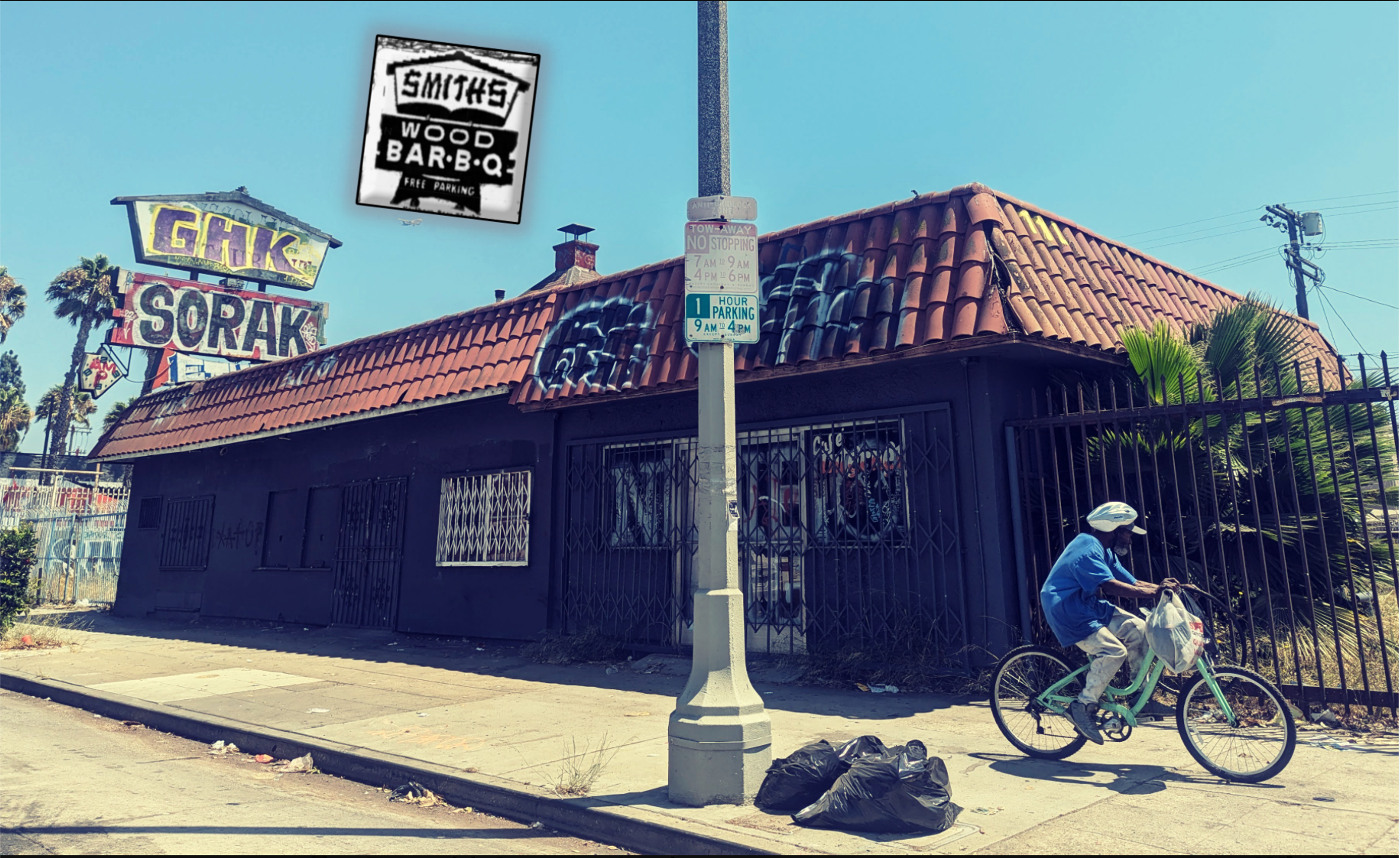 226 W. Manchester Avenue, a single-story building painted black with a red barrel tile roof and tagging.