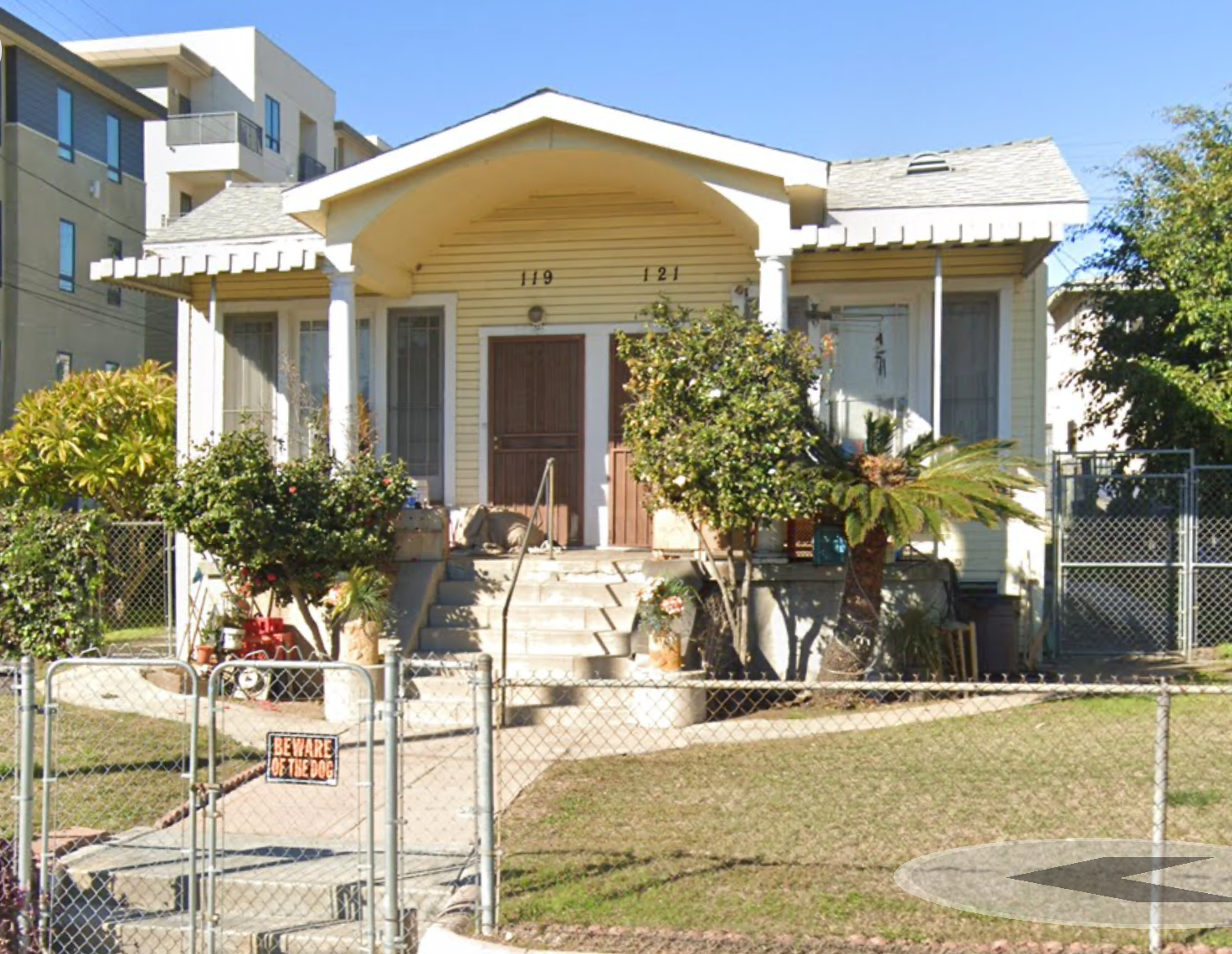 119-121 N. Mathews Street, a small yellow duplex, taken in 2022. 