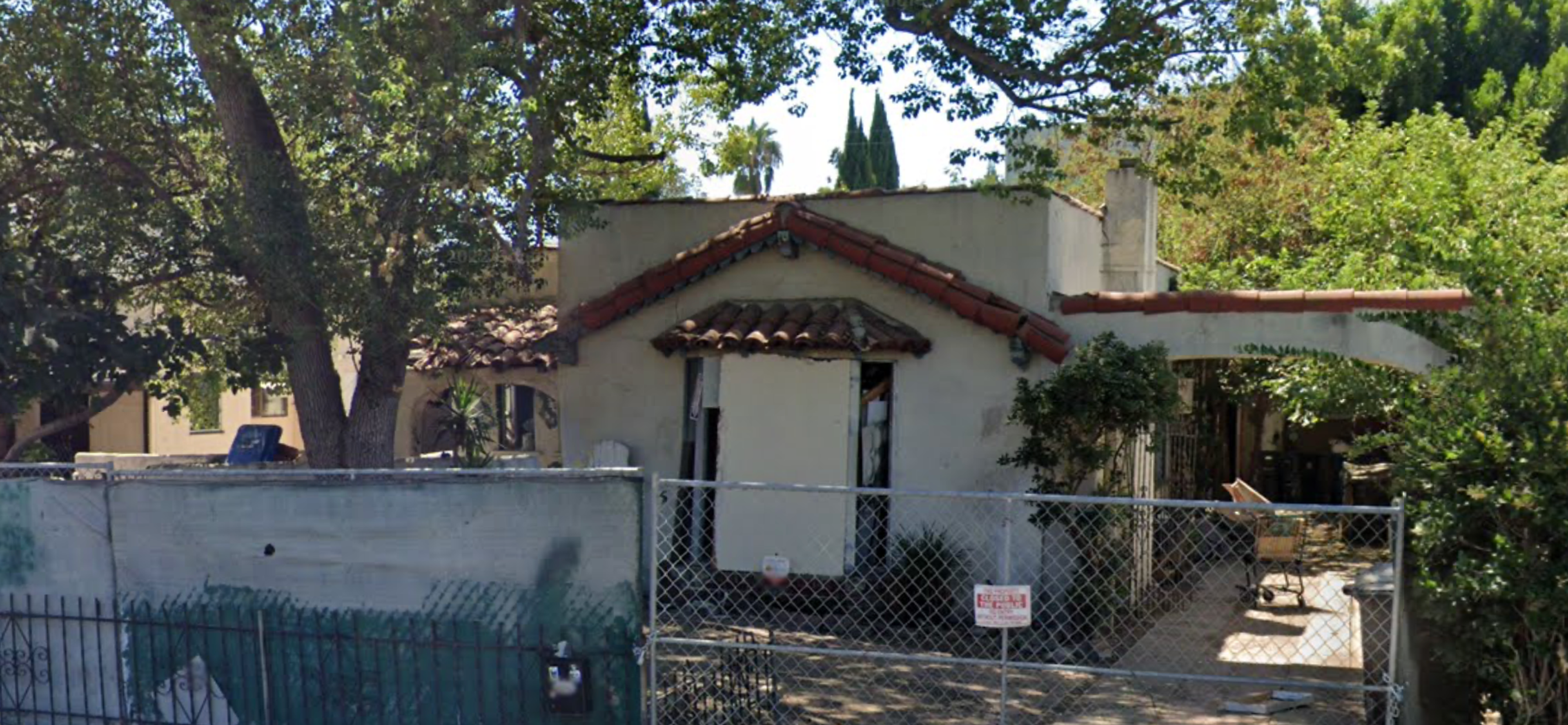Screenshot of 10936 Otsego Street, a Spanish-style cottage with a fence, boarded up windows, and obvious signs of neglect.