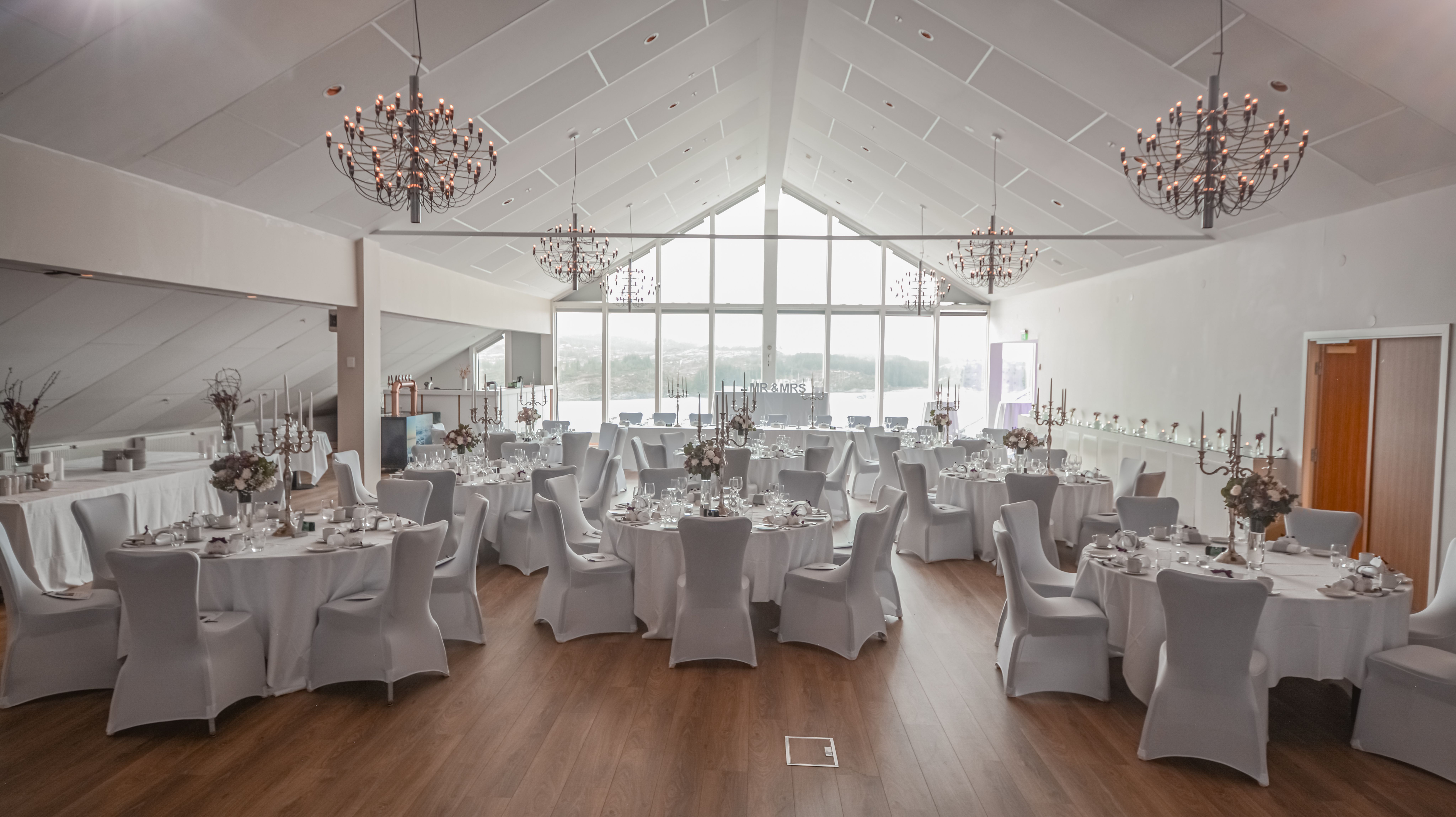 Beautiful set tables for 50 people with sea view out through the large windows. This is the "Storm hall" in Panorama hotel
