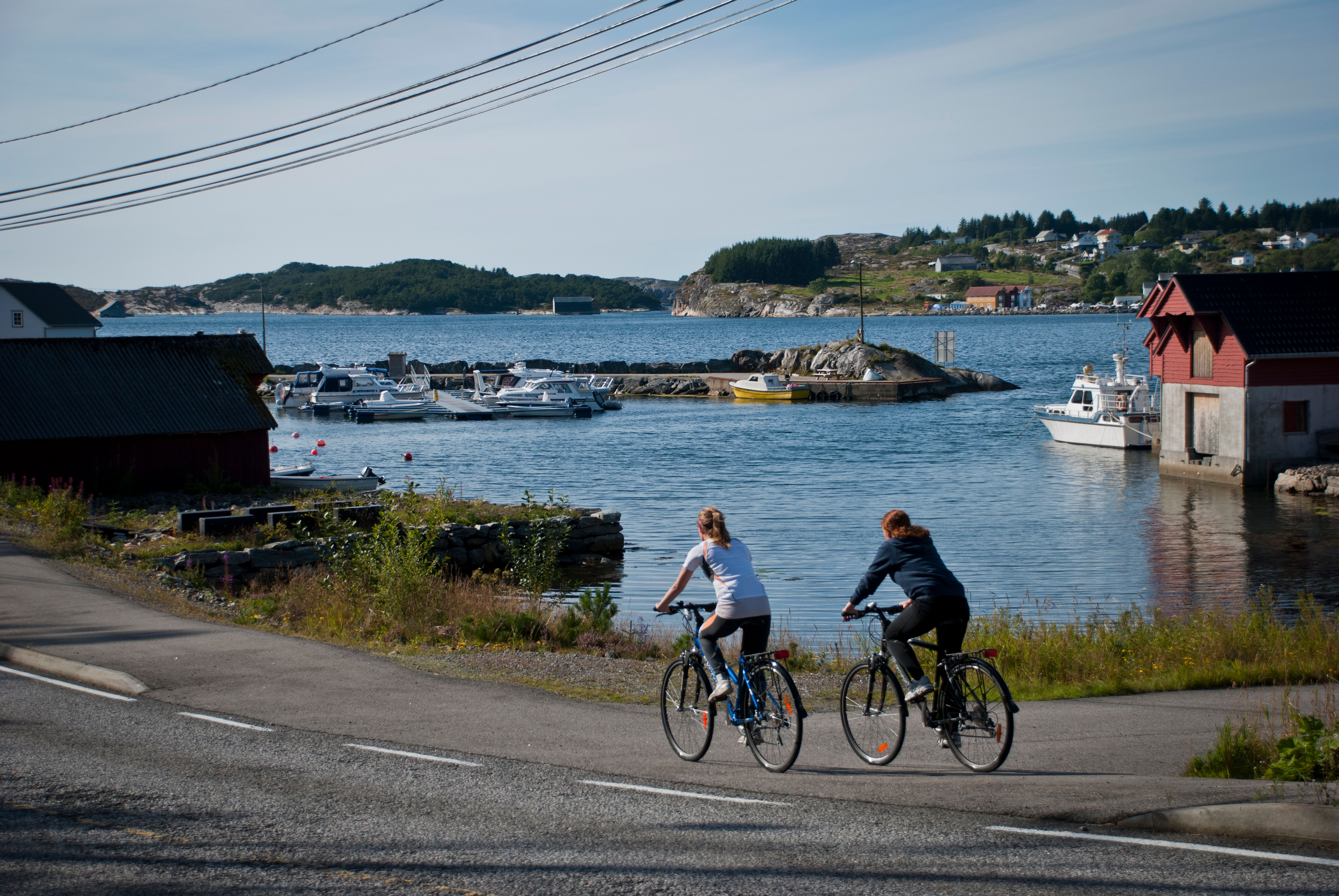 Two guests riding electric bikes by the coast, near Panorama hotel