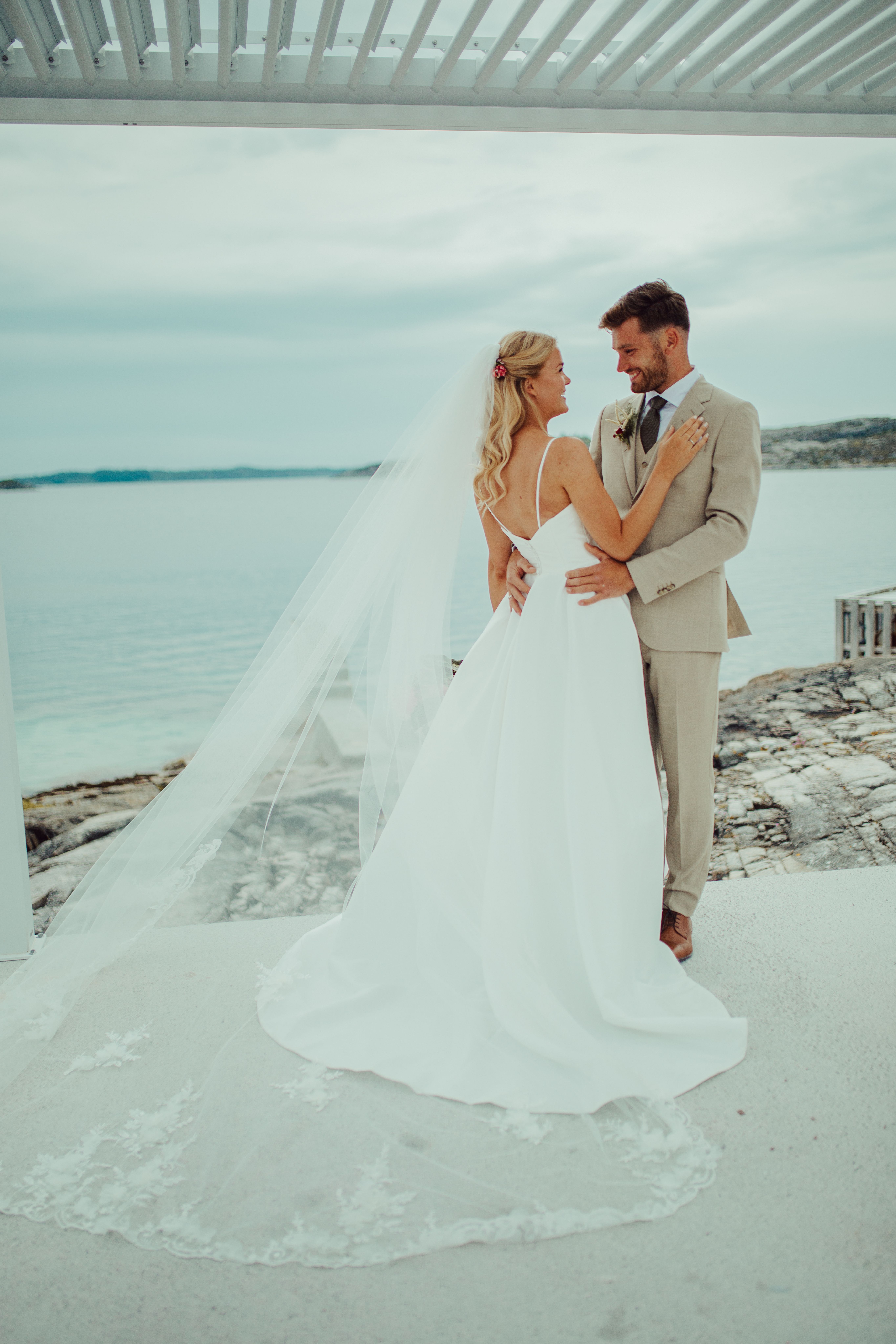 Bildet viser et bryllupsbilde av et brudepar ved sjøen