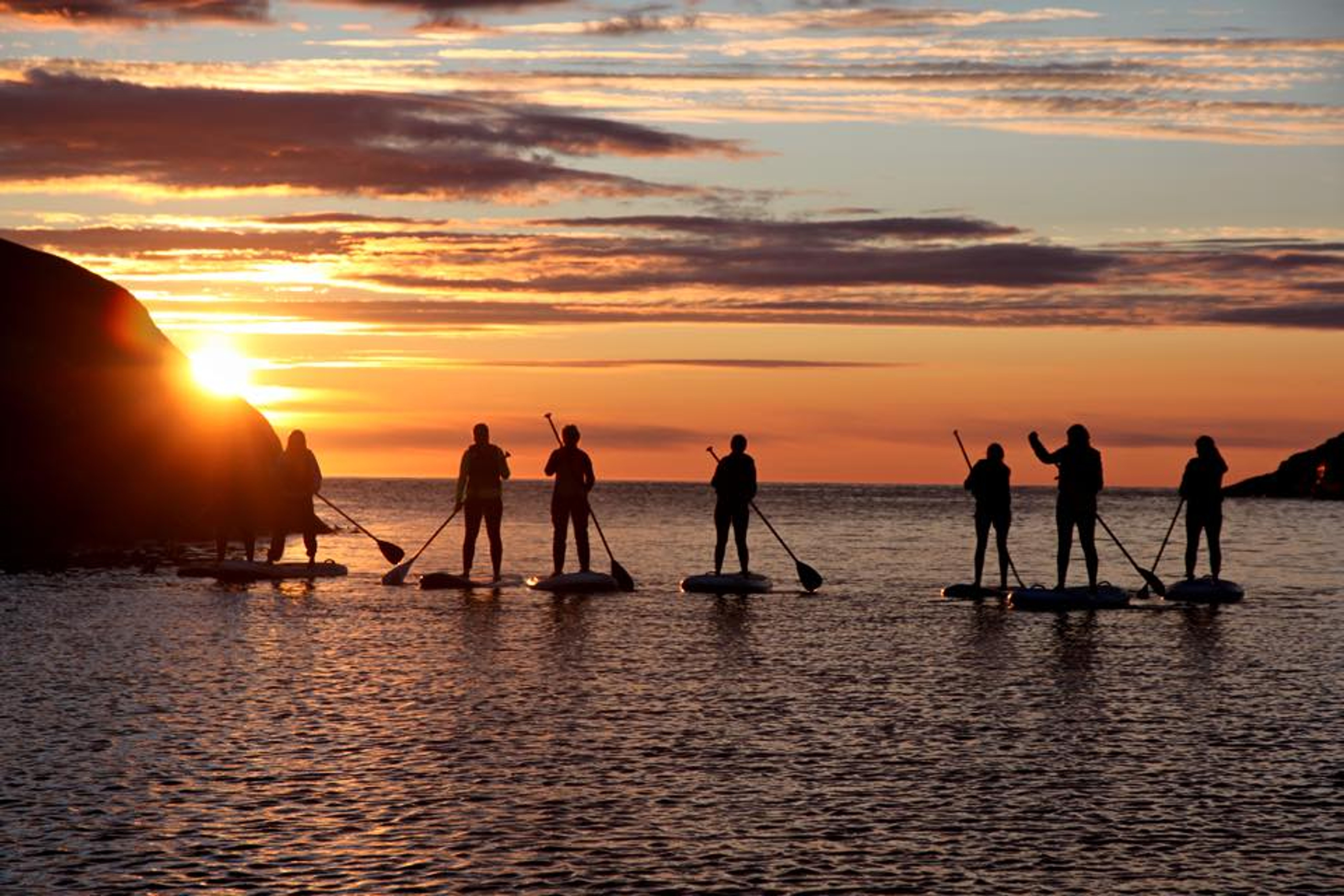 Bildet viser sup-board på sjøen med solnedgang