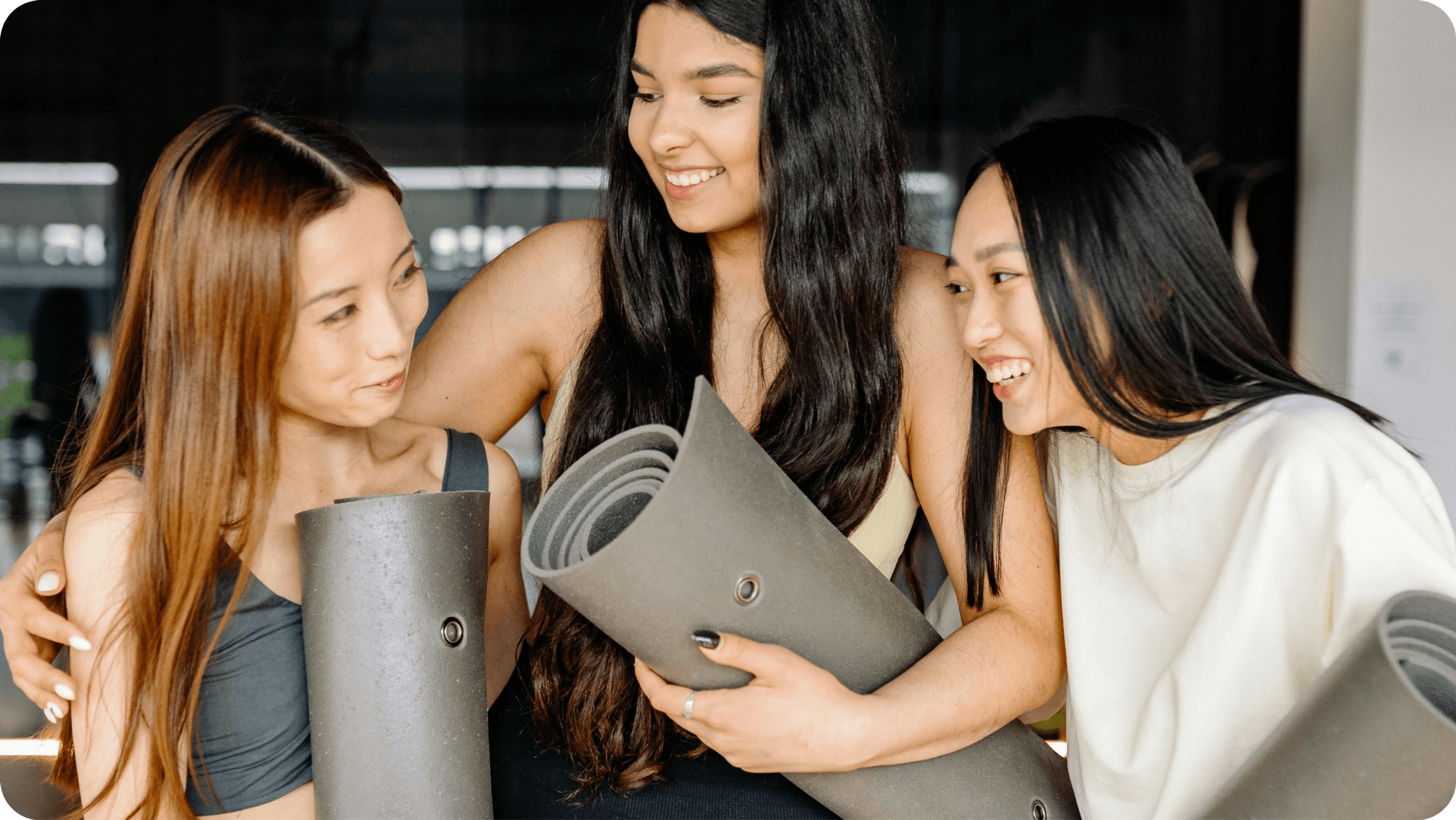Yoga people holding a mat and laughing
