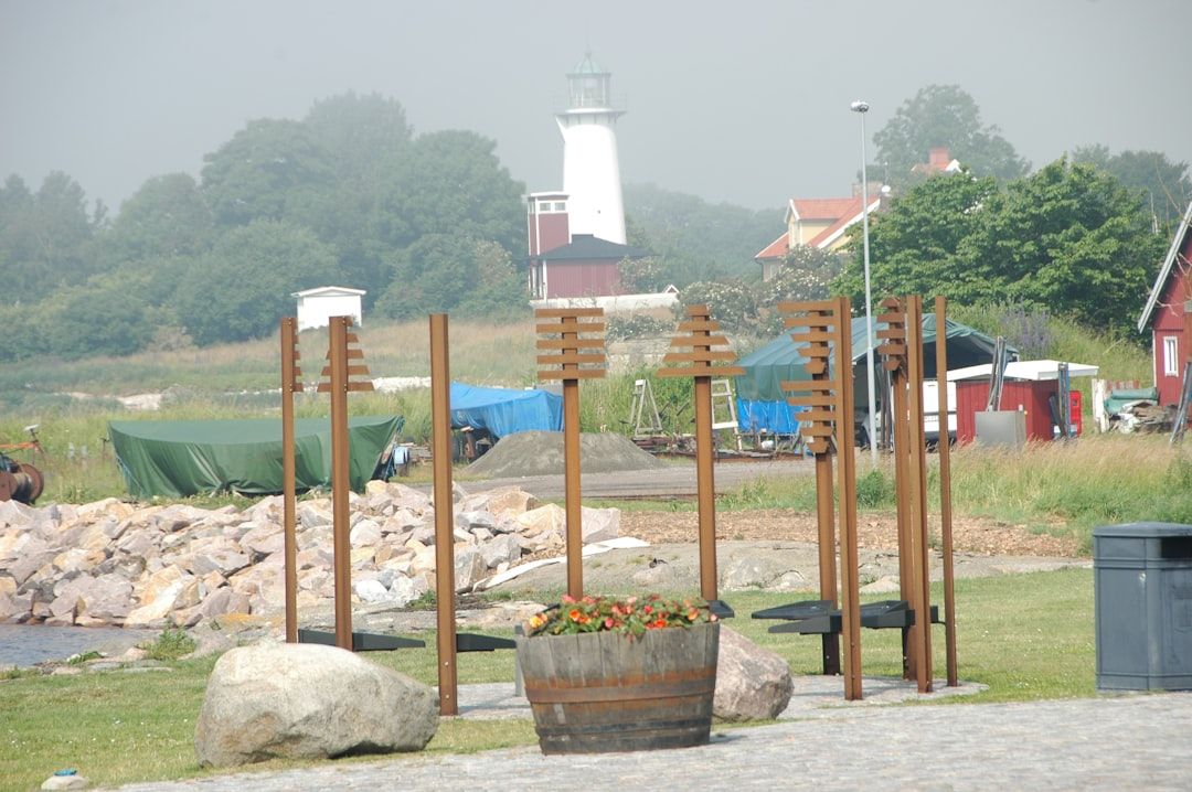 A bunch of wooden poles sitting on top of a grass covered field