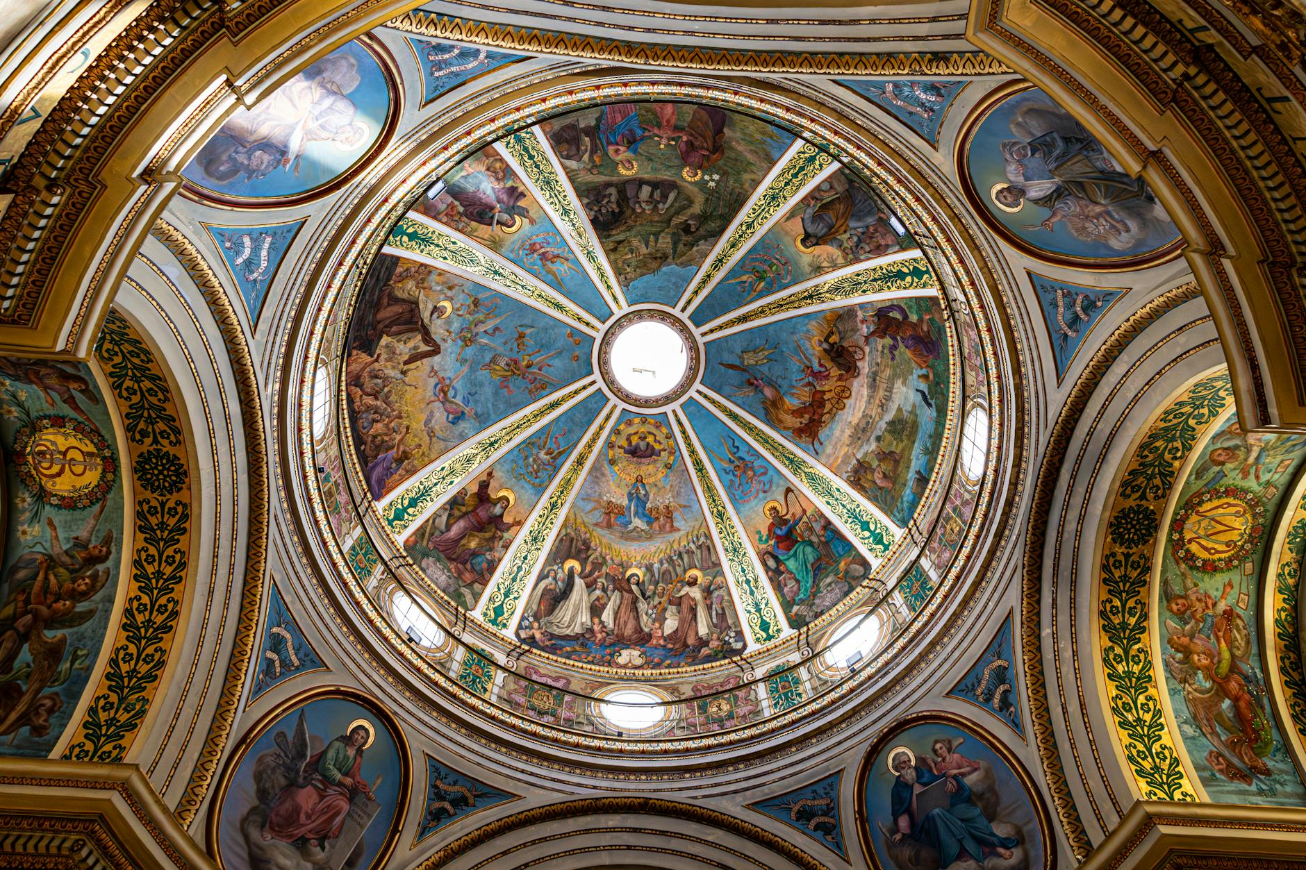 Stunning dome ceiling showcasing detailed religious art in an ornate cathedral.