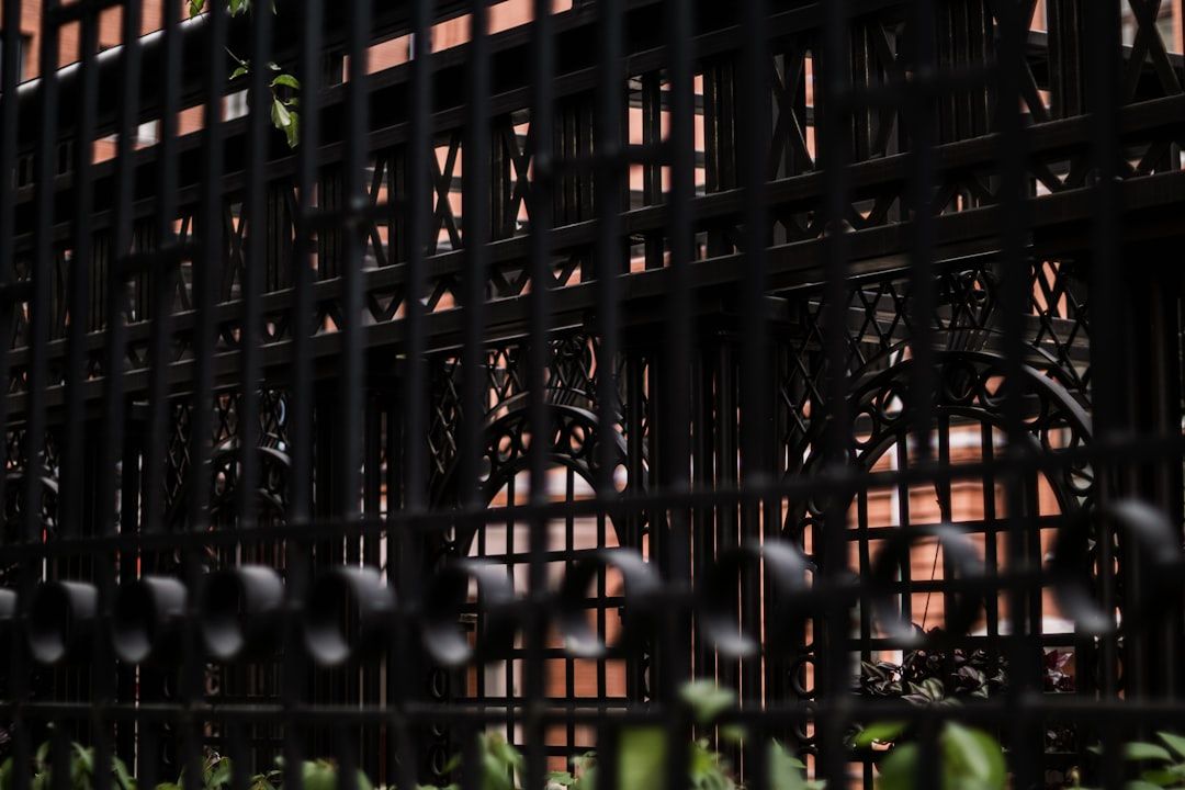 Black metal fence in front of brick building