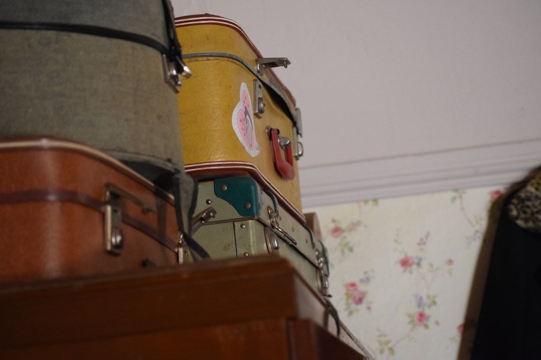 A stack of luggage sitting on top of a wooden dresser