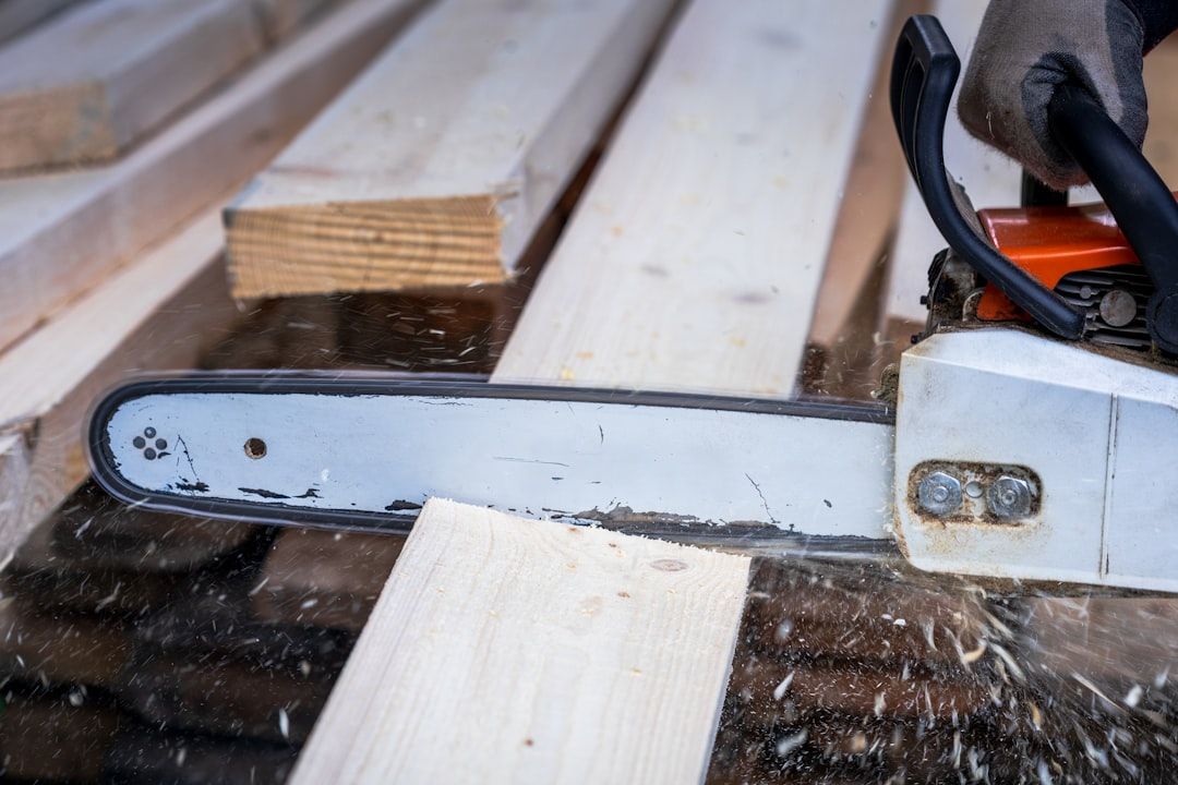 A chainsaw is cutting through a wooden plank.