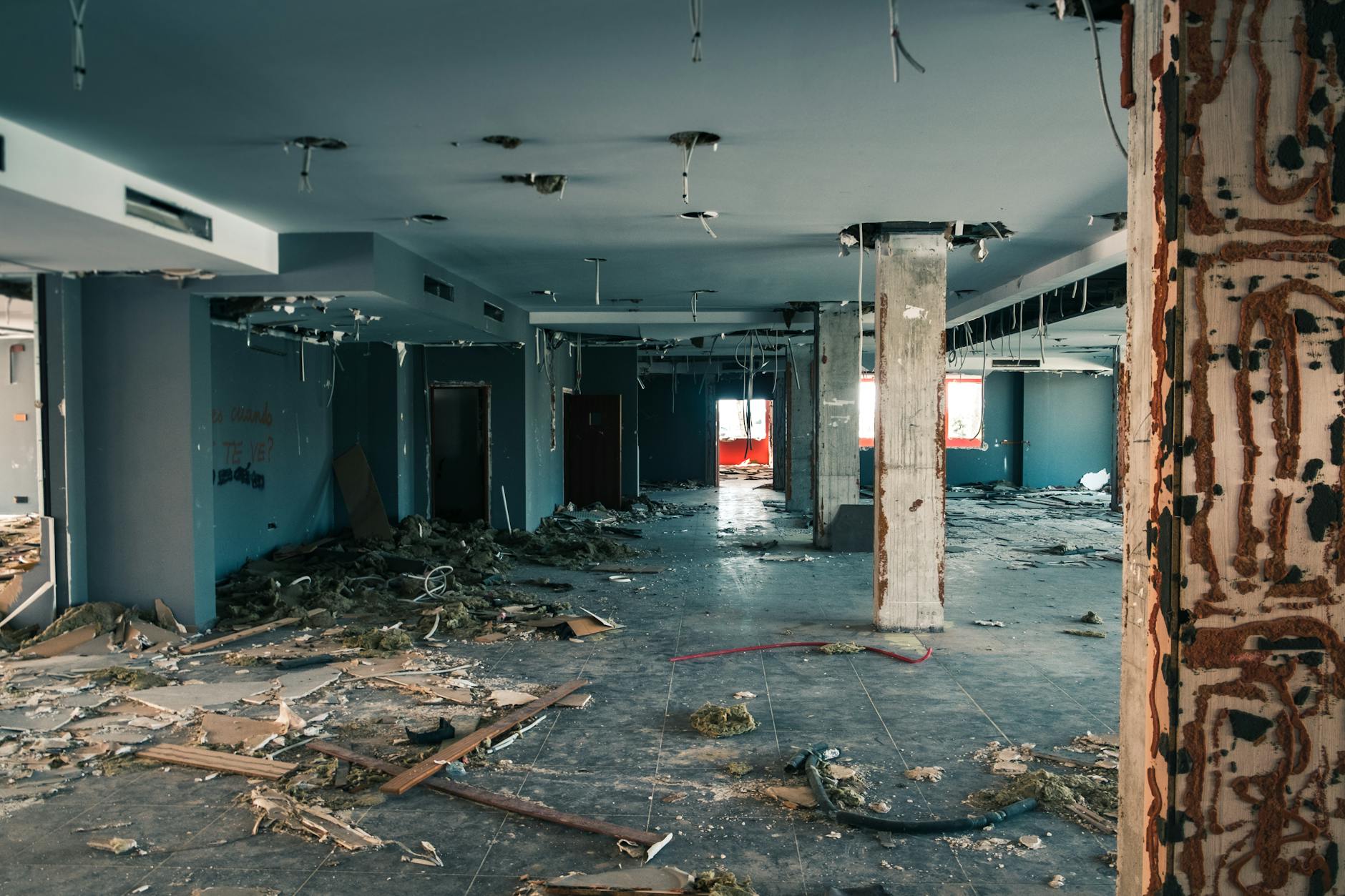 Interior of an abandoned building showing decay and debris scattered across the floor.