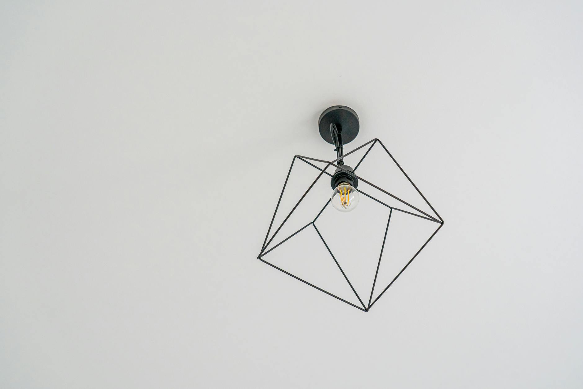 Sleek geometric ceiling light design against a white background.