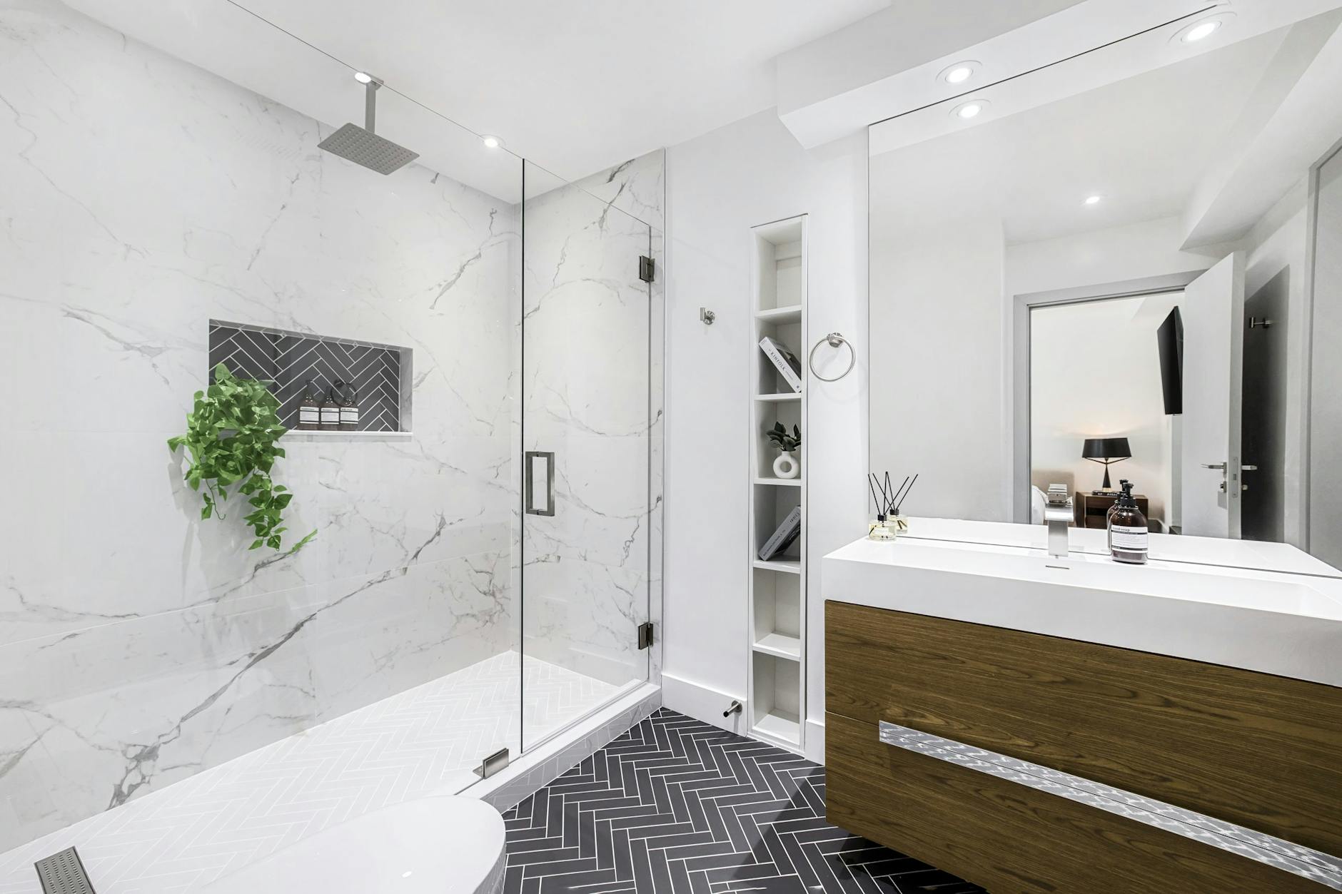 Elegant modern bathroom interior with a glass shower and marble walls.