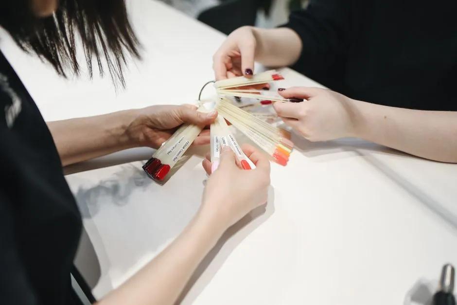 Händer väljer nagellack i salong inför gelmanikyr