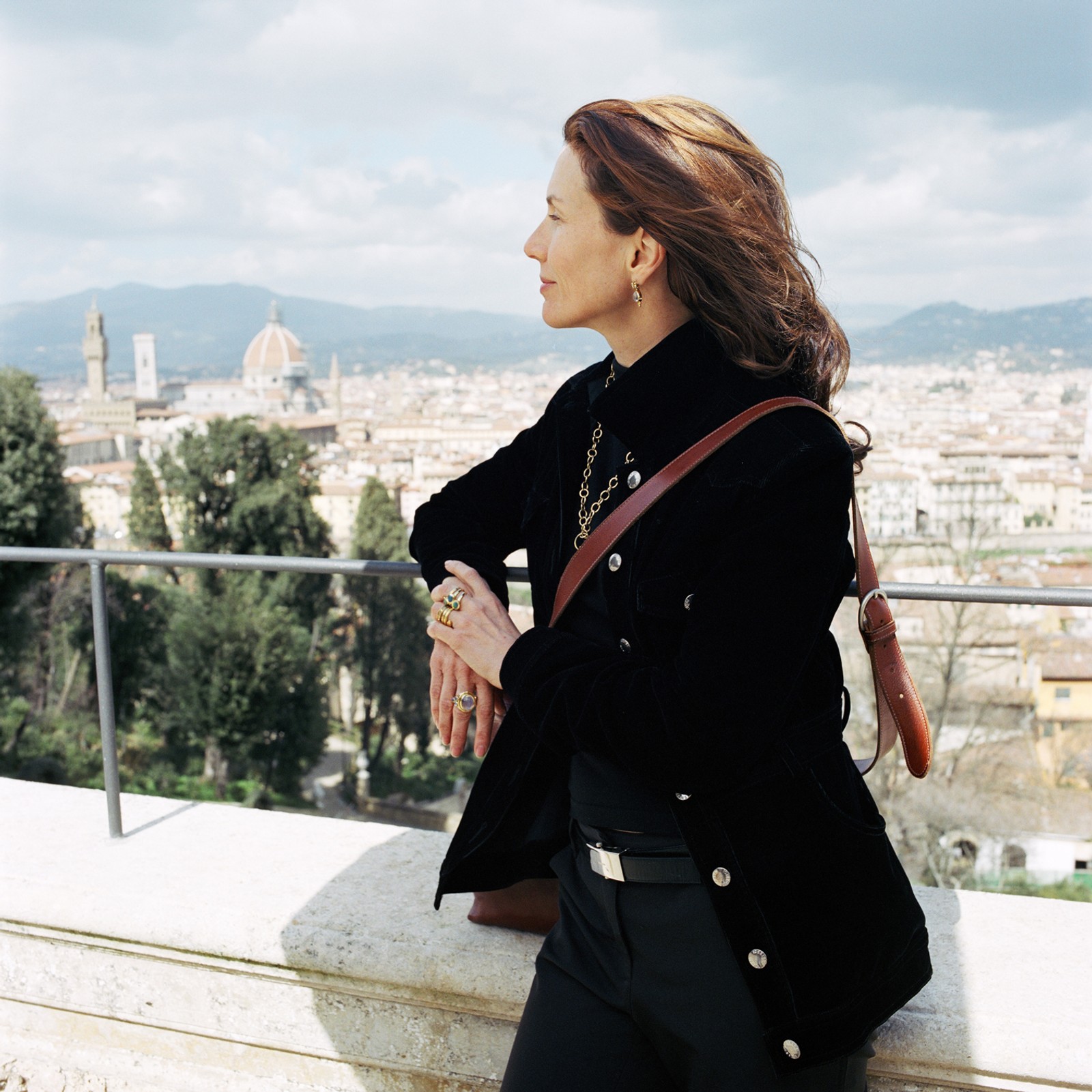 Woman in a black jacket looking out at the Florence cityscape, with the Duomo visible.