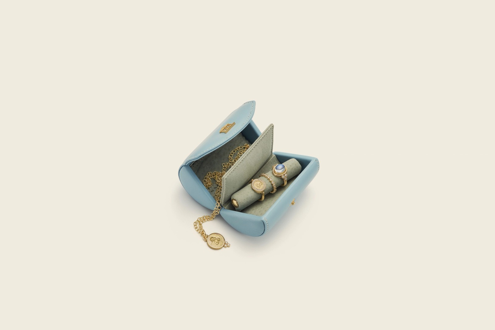 Open light blue travel jewelry box with gold necklace and two rings.