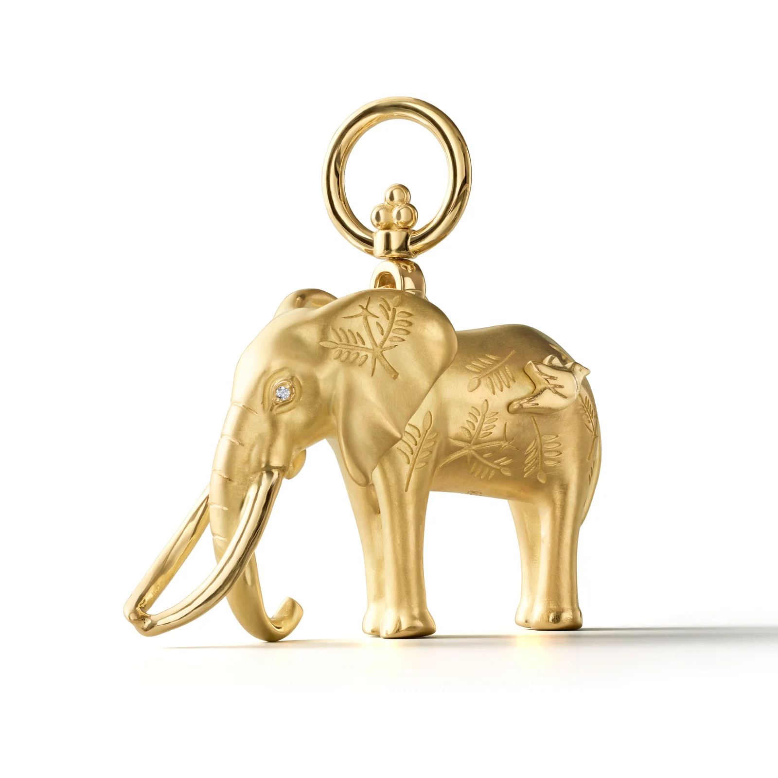 Gold elephant charm with leaf engravings, diamond eye, and a bird on its back.