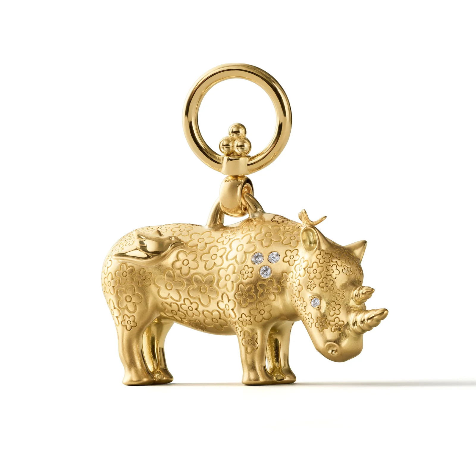Gold rhinoceros charm with engraved floral patterns, three diamonds, and an attachment ring.