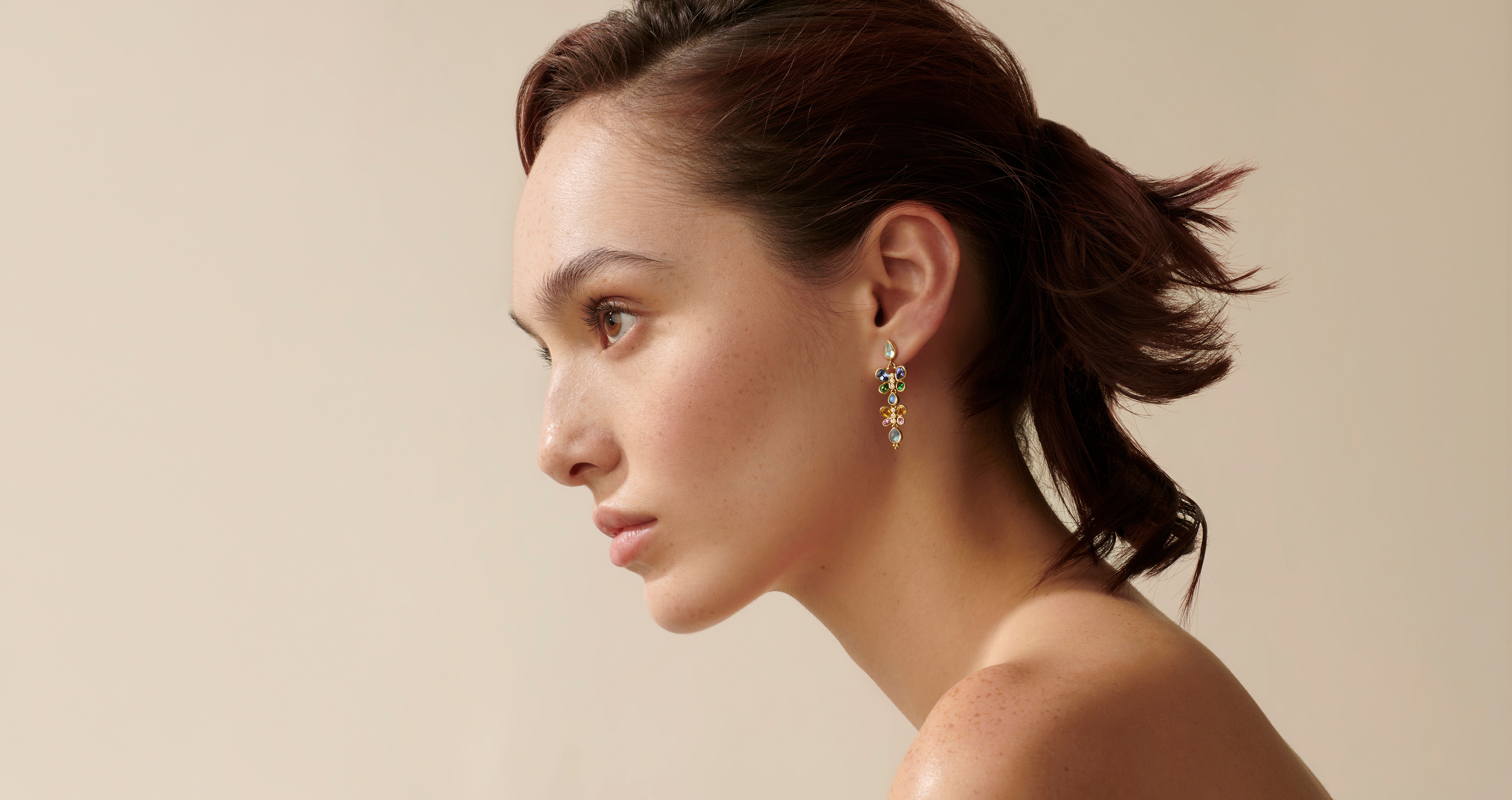 Profile of a woman wearing a colorful dangle earring.