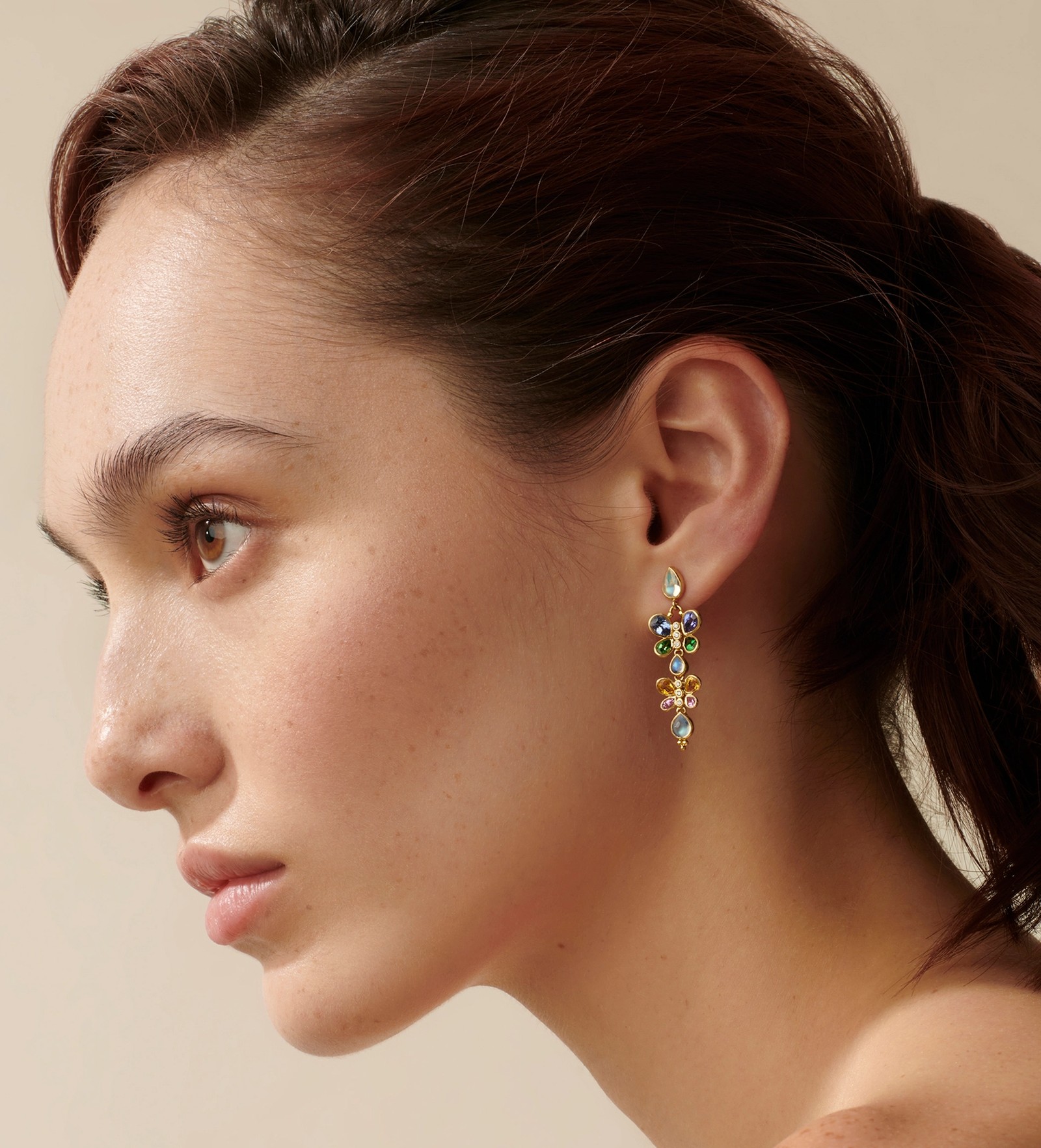 Profile of a woman wearing a colorful dangle earring.
